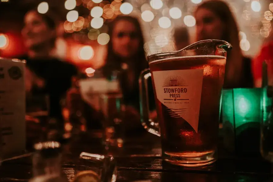 Gäste stoßen im Broderick Irish Pub an, im Hintergrund Lichterketten