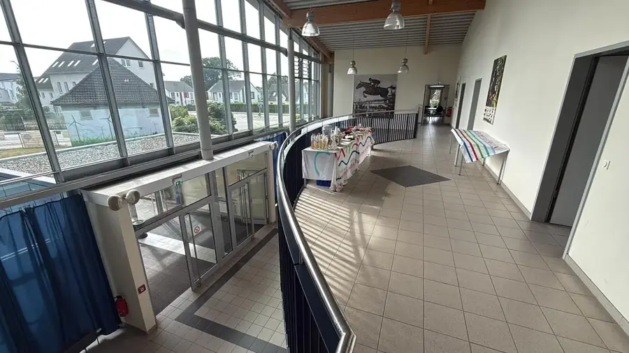 Das Foyer der Verbandsanlage in Elmshorn: hohe Glasfassade, umlaufende Galerie und Empfangstische