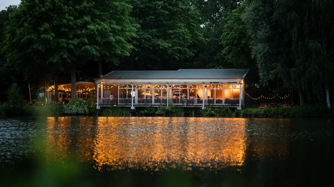Harry's – Haus am See in Elmshorn am Abend: Lichterketten spiegeln sich im See